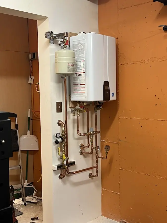 Plumbing technician inspecting water heater connections in Centerton